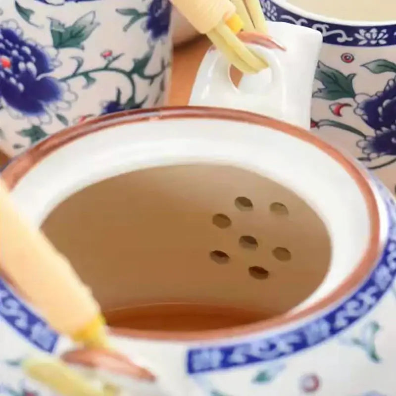 White porcelain tea strainer with blue floral patterns and brown rim for decorbites blue and white porcelain teapot set