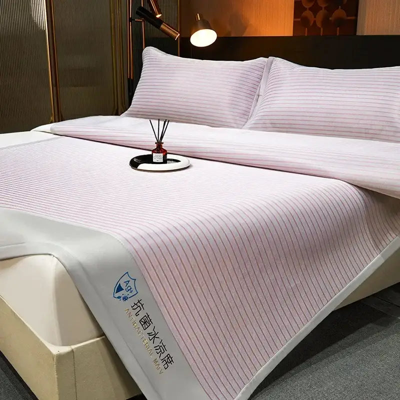 Pink striped cooling bed mat with white border and embroidered decorbites cooling bed branding in mat set