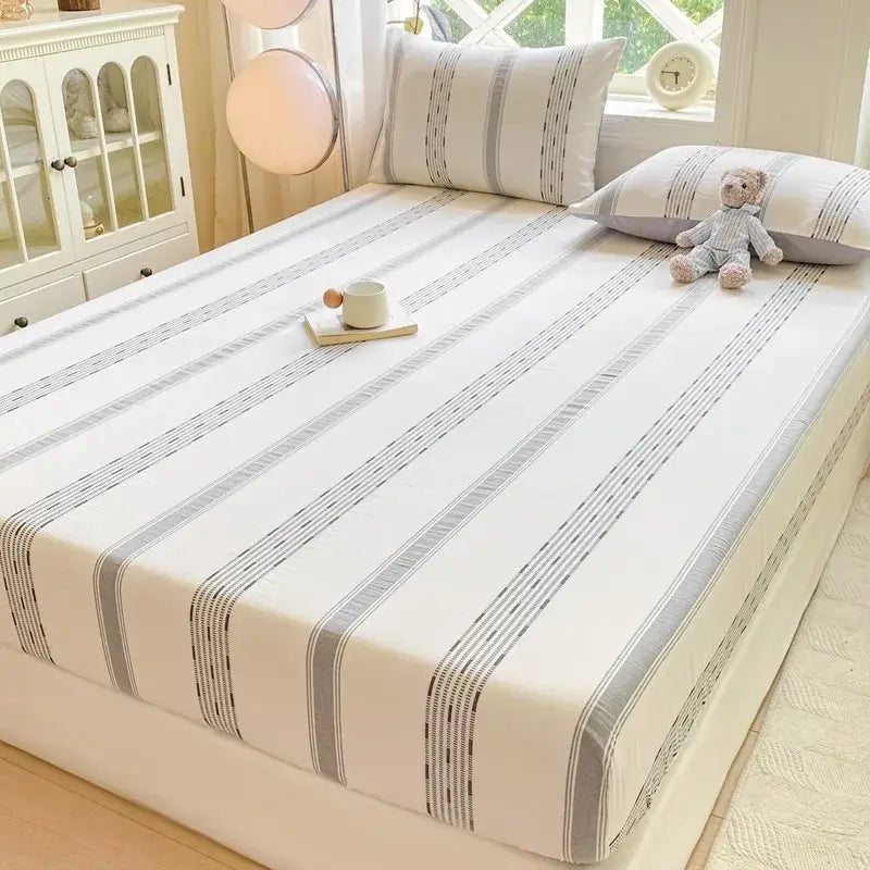 White fitted sheet with gray vertical stripes and subtle dotted detailing in blue and white striped cotton jacquard sheet set