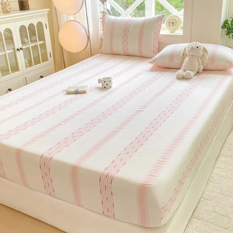 A soft white and pink striped cotton jacquard fitted sheet set for bedroom use with delicate dotted accents