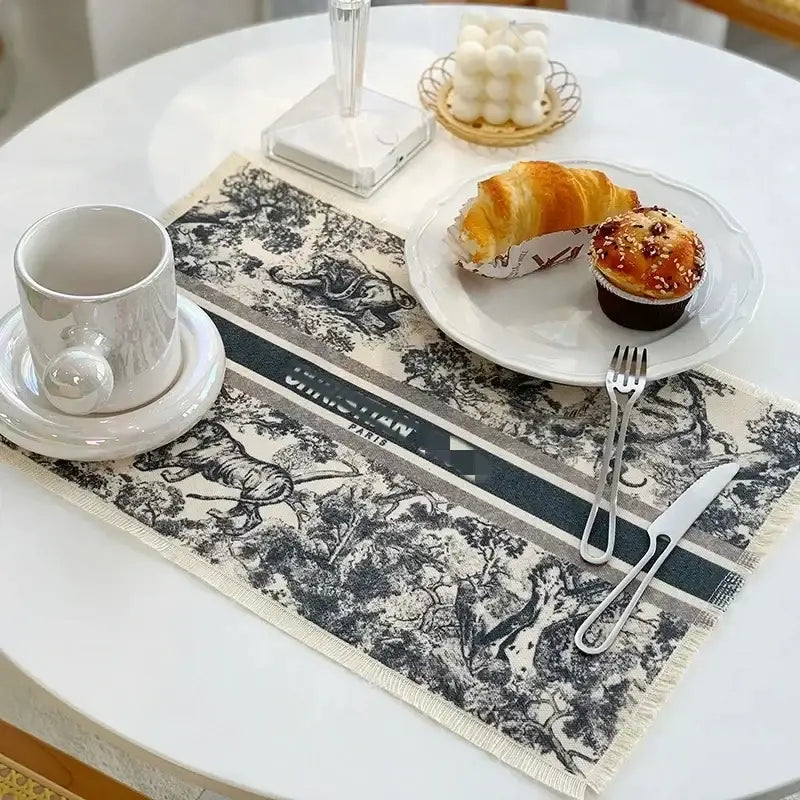 Black and white cotton linen place mat with frayed edges featuring a classic dior-inspired pastoral scene decorbites cotton linen
