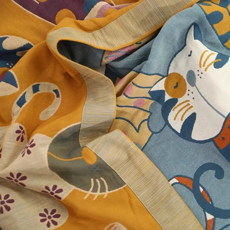 A soft cotton leisure blanket with a playful decorbites cartoon cat pattern in vibrant yellow and blue tones for summer use