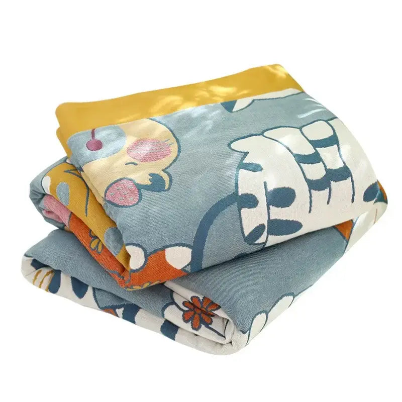 Stacked plush cotton blankets with cartoon cat prints in blue yellow and orange tones and shiny gold border for decorbites cartoon cat summer use