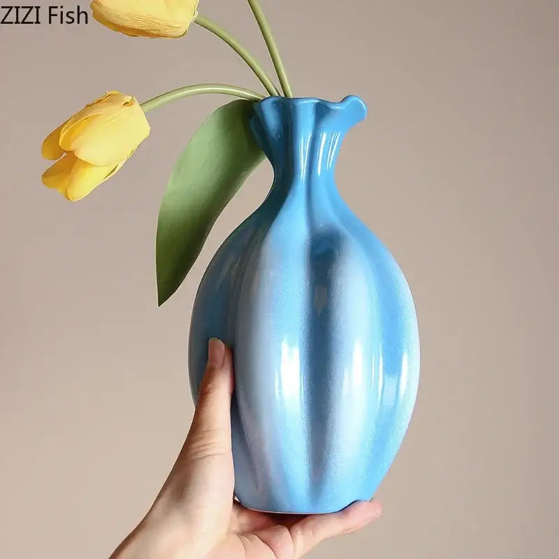 Glossy light blue decorbites blue ceramic flower bud vase with fluted neck holding two yellow tulips for living room decor