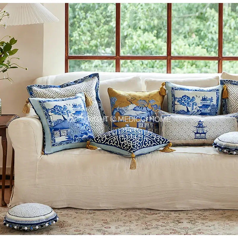 A collection of decorative blue chinoiserie home pagoda bolster pillowcases with traditional porcelain designs and gold tassels
