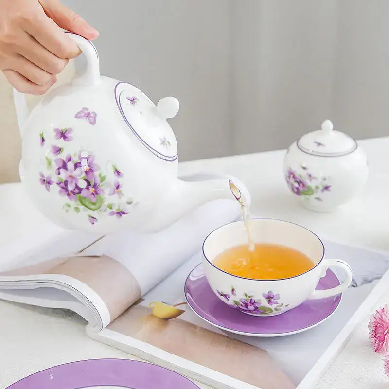 White porcelain tea set teapot with purple violet blossoms and green leaves from the blue dream tea set