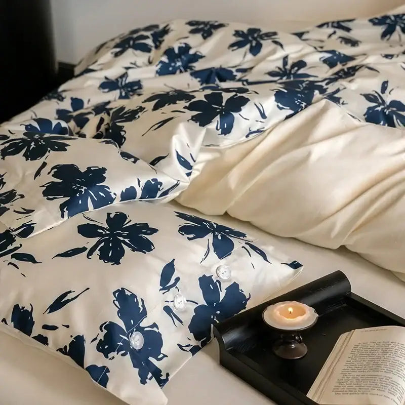 Cream-colored satin duvet cover with bold navy blue floral pattern and white buttons in decorbites 100s egyptian cotton bedding set