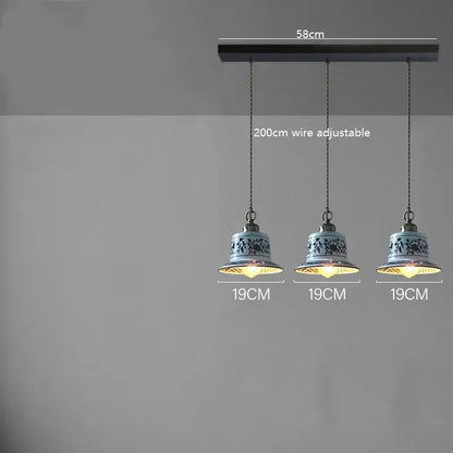 Three blue and white floral ceramic led pendant lamps hang from a dark wooden bar for dining room lighting decorbites ceramic led