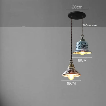 Two ceramic led pendant lamps with blue floral and red brown patterns featuring brass-colored decorbites ceramic led fixtures
