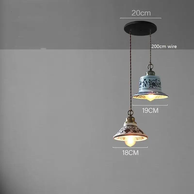 Two ceramic led pendant lamps with blue floral and red brown patterns featuring brass-colored decorbites ceramic led fixtures