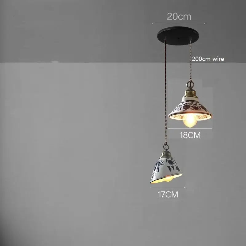 Two blue floral ceramic led pendant lamps with black patterns on white ceramic, suspended by dark chains for dining room lighting