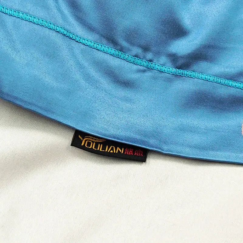 Blue floral satin jacquard duvet cover set featuring a vibrant blue satin towel with teal stitched edge and you lian label