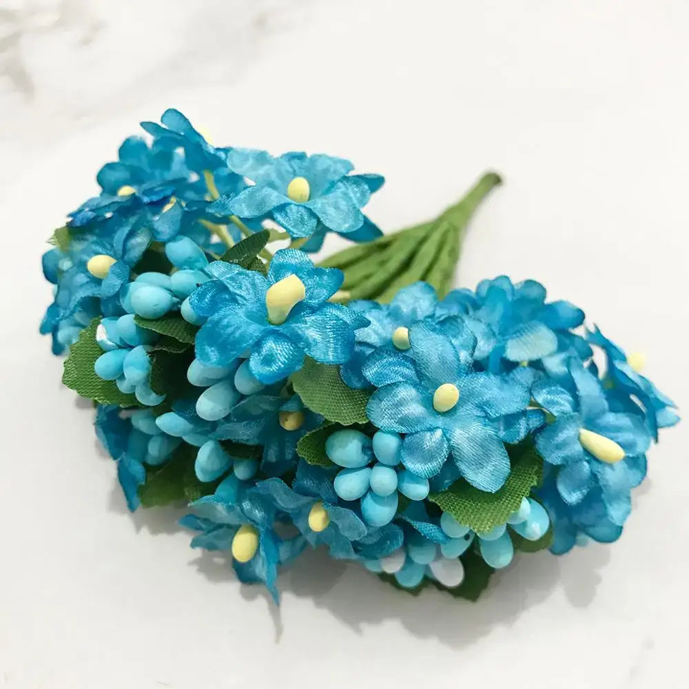 A decorbites blue flower cherry stamen bundle featuring artificial blue hydrangeas with yellow centers and green leaves