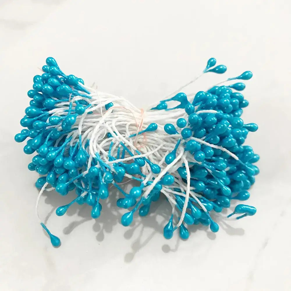A bundle of turquoise plastic blue flower cherry stamen berries with white stems tied for living room decorbites decor