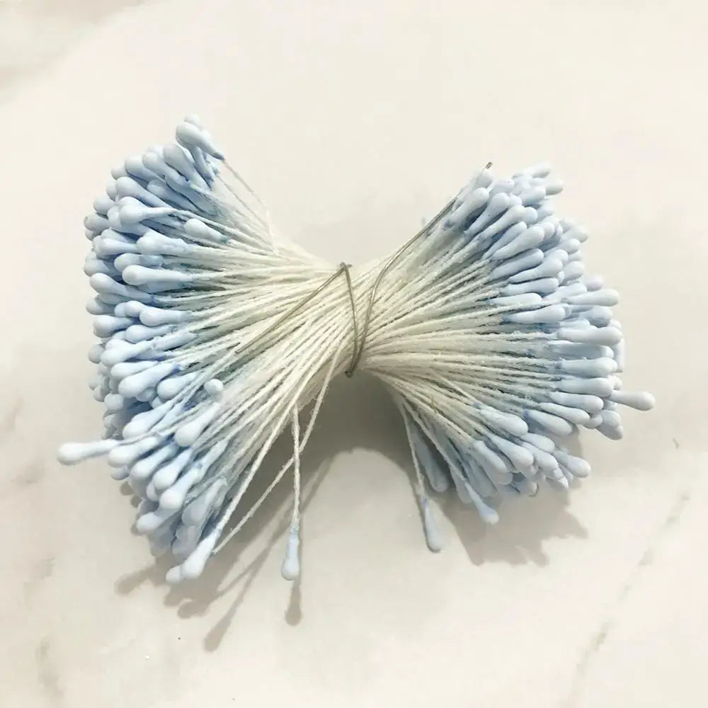 A bundle of light blue cotton swabs tied with a string resembling decorbites blue flower cherry stamen berries for decor