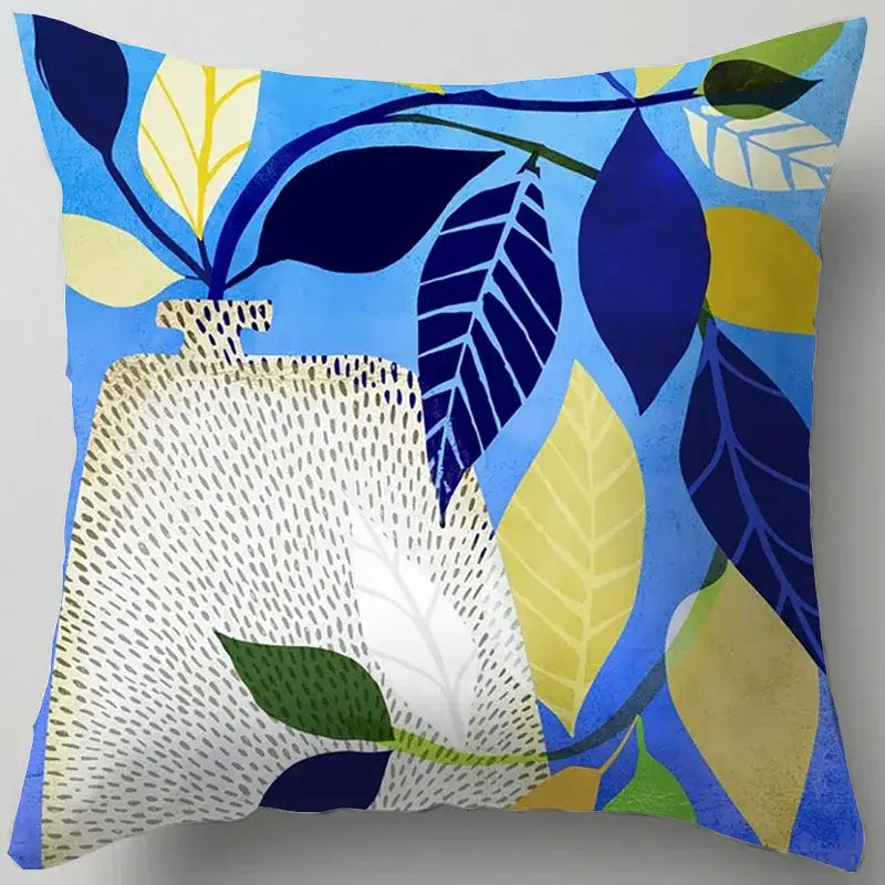 Blue flower leaves pattern throw pillow with blue and yellow leaf design and textured white vase decorbites blue flower cover