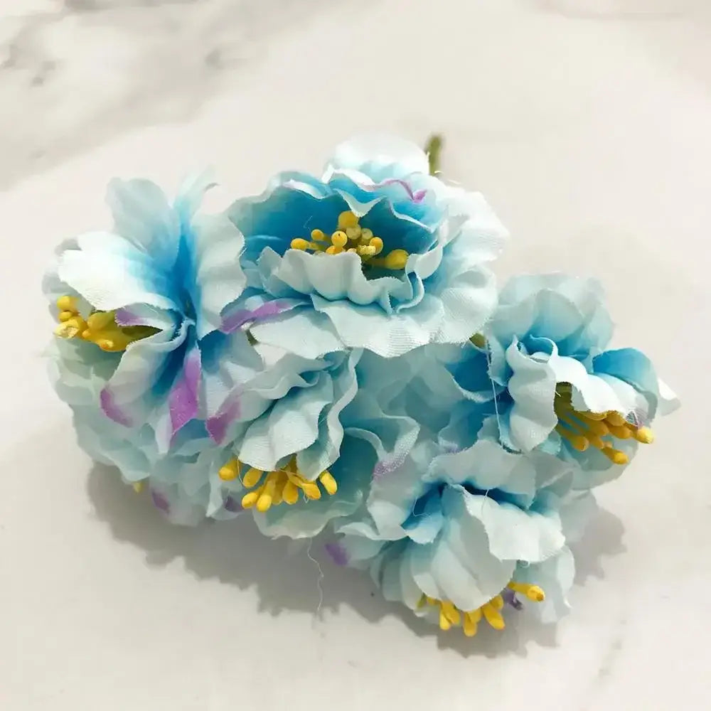 A blue flower stamen berries bundle featuring delicate light blue white artificial flowers with yellow centers for cake decor