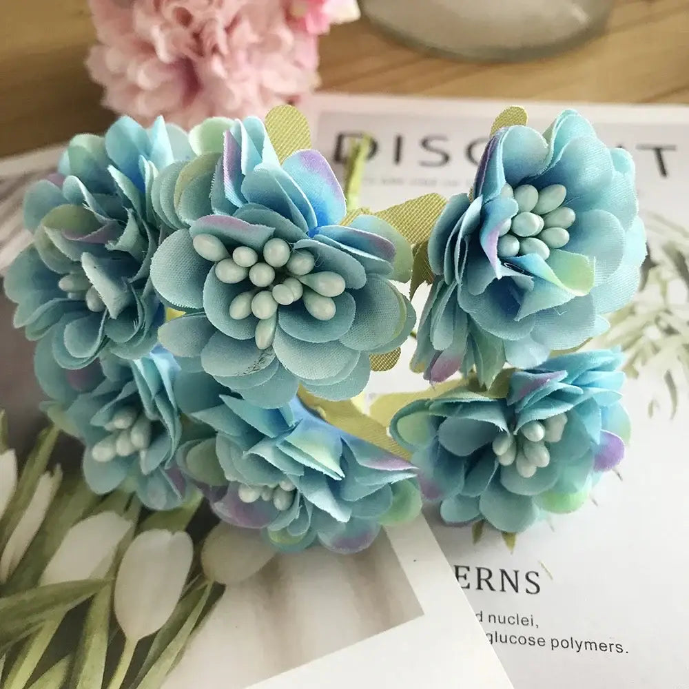 A cluster of delicate light blue fabric blue flower stamen berries with subtle purple and green accents for kitchen cake decor