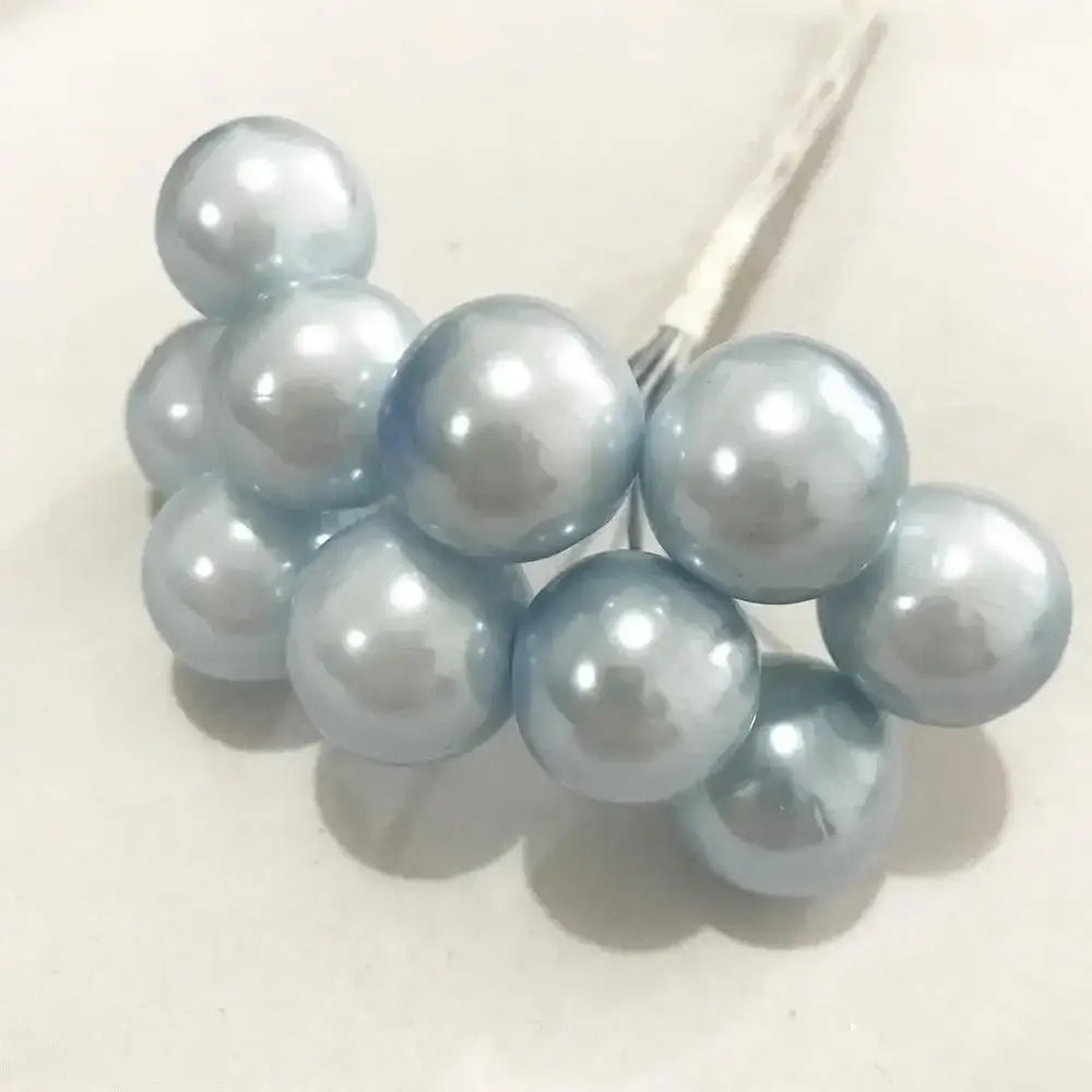 A cluster of light blue glossy pearl-like flower stamen berries attached to a thin metal stem for cake decor