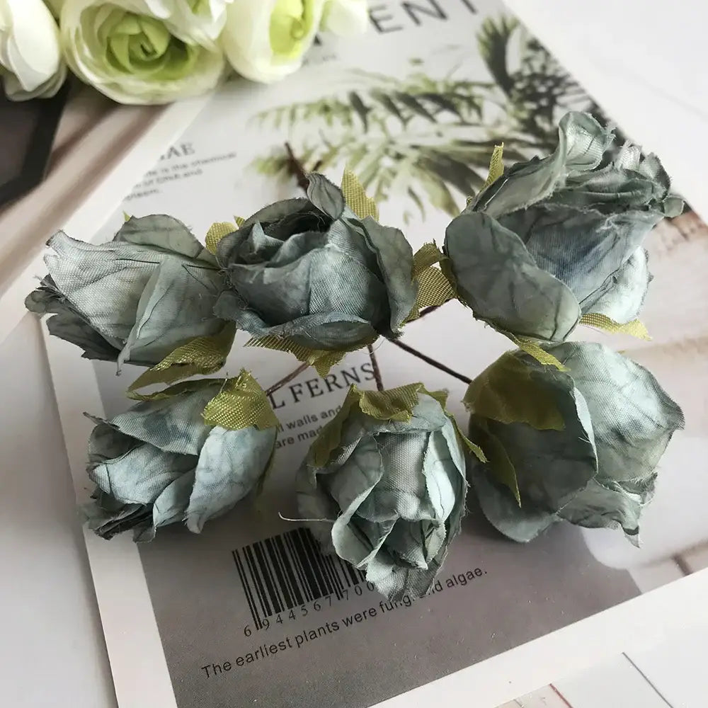 A stamen berries bundle of artificial blue flower stamen with muted sage green fabric roses and yellow petal accents