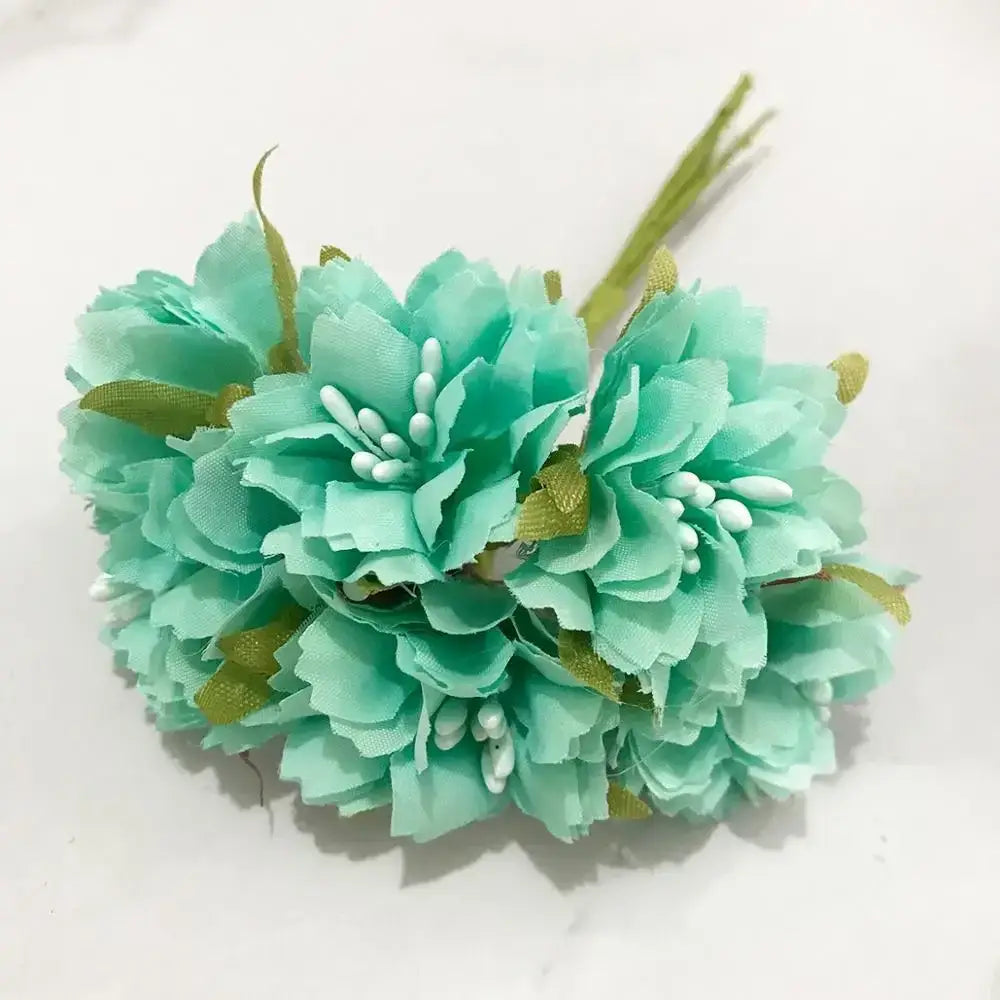 A cluster of artificial mint green fabric flower stamen berries with gold ribbon accents in a stamen berries bundle
