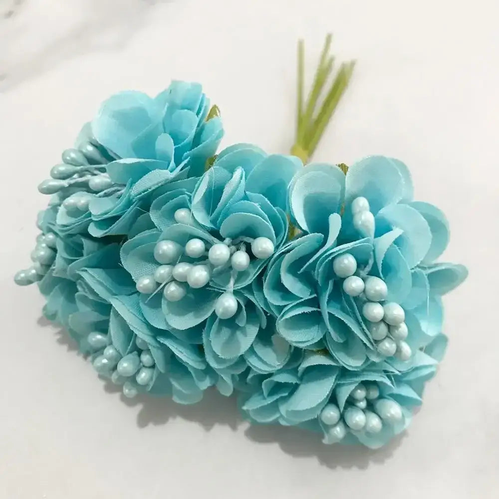 A bundle of light blue flower stamen berries with fabric petals and pearl details for kitchen cake decor