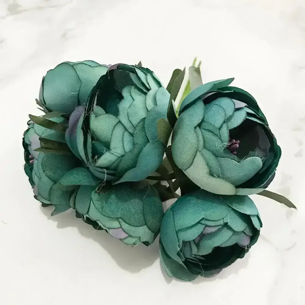A cluster of artificial teal fabric blue flower stamen berries bundle with layered petals and green stems for kitchen cake decor