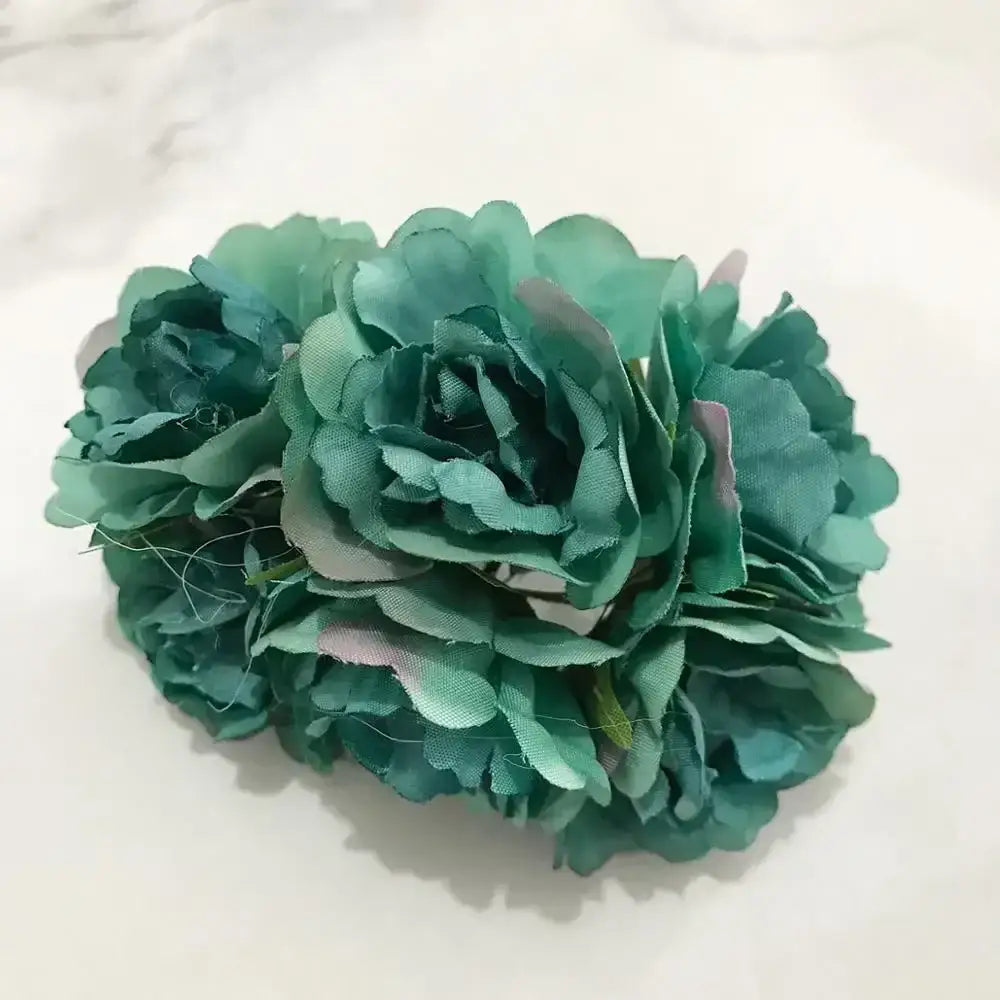 A cluster of teal fabric blue flower stamen berries with layered petals and subtle pink accents for cake decor
