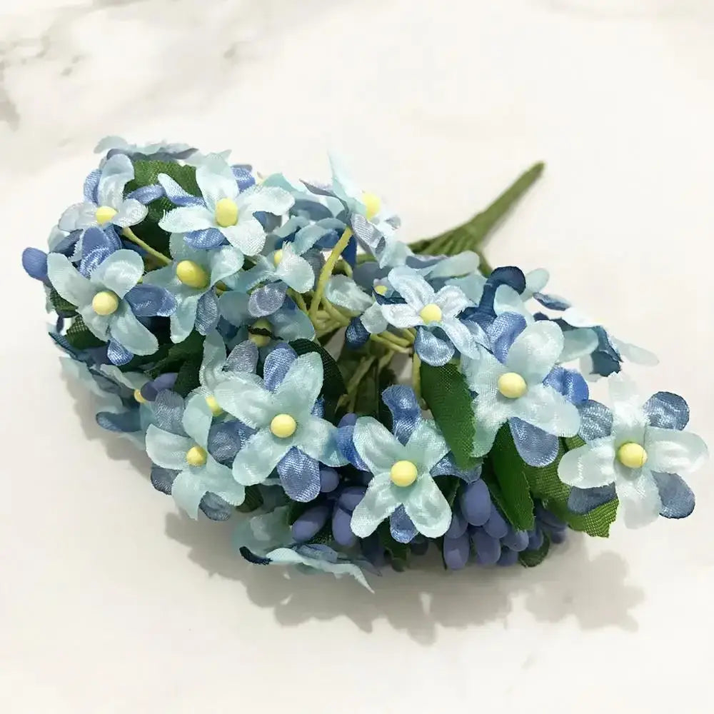 A delicate bundle of artificial blue flower stamen berries with translucent petals and vibrant yellow centers for decor