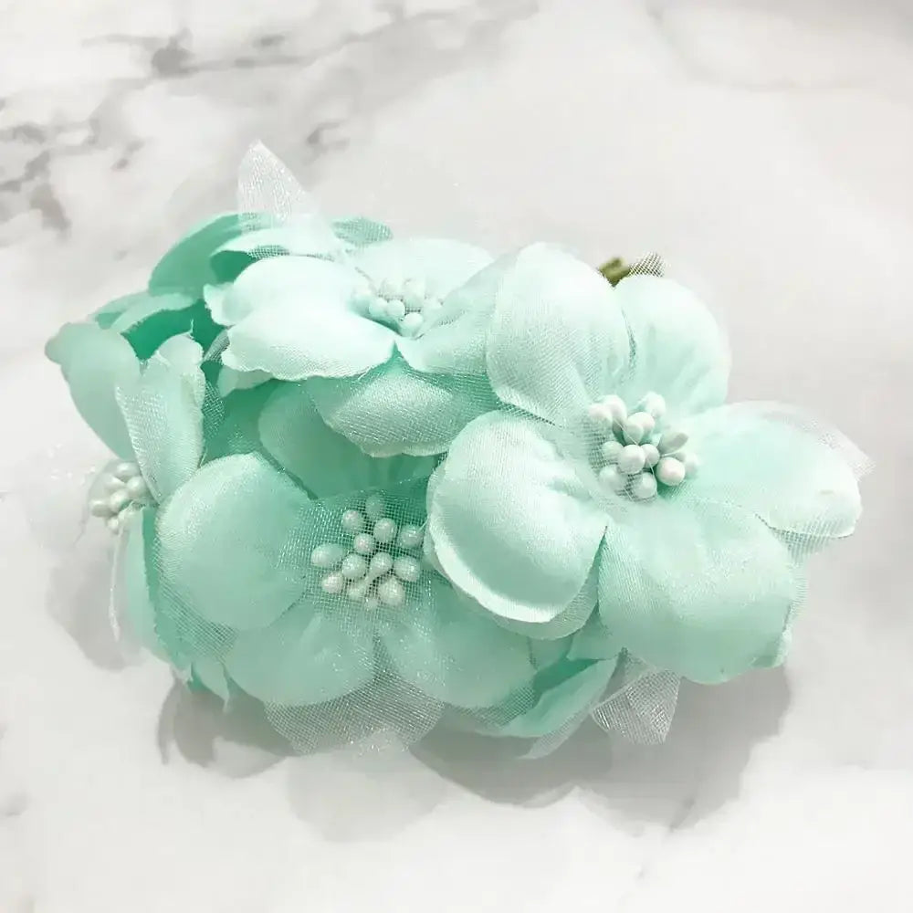 A delicate cluster of mint green fabric blue flower stamen berries with beaded centers for kitchen cake decor