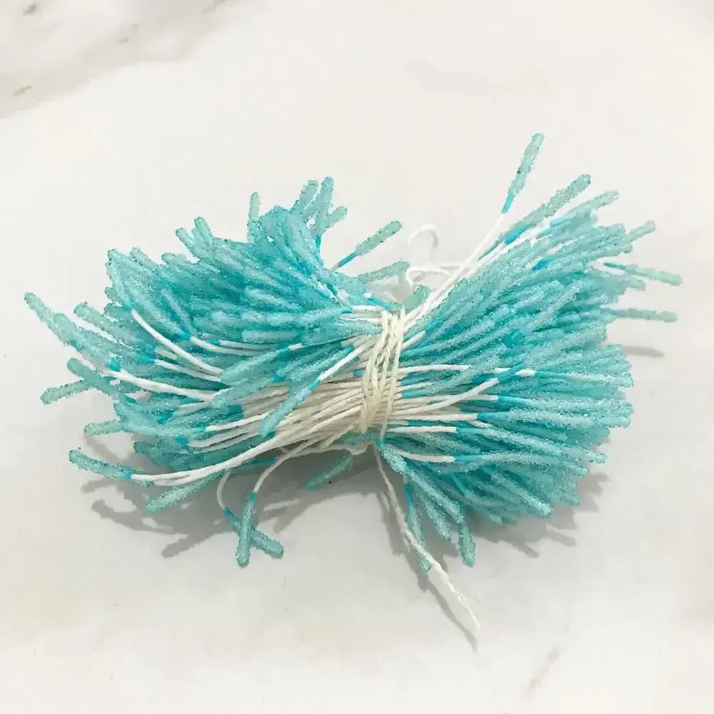 A bundle of turquoise and white sugar-coated candy sticks tied with string for blue flower stamen berries bundle decor
