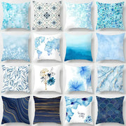 A collection of blue geometric marble throw pillows with various patterns including maps and floral motifs for living room decor