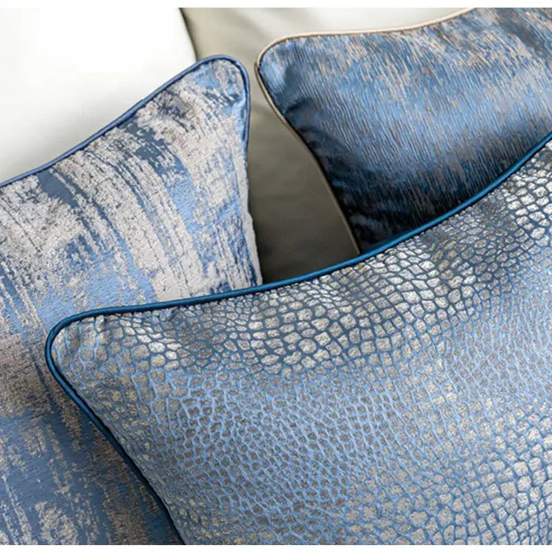 Blue geometry jacquard pillow cover featuring blue and silver faux leather and velvet textured throw pillows for living room decor