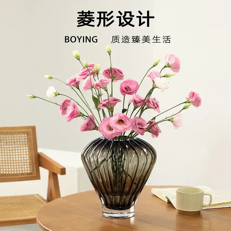 A dark ribbed glass hot air balloon vase with diamond design holds pink and white flowers for living room decor