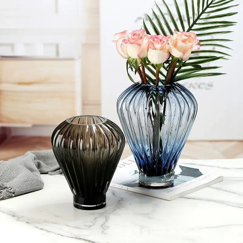 A sleek ribbed deep blue to transparent glass hot air balloon vase with a sturdy base for living room decor