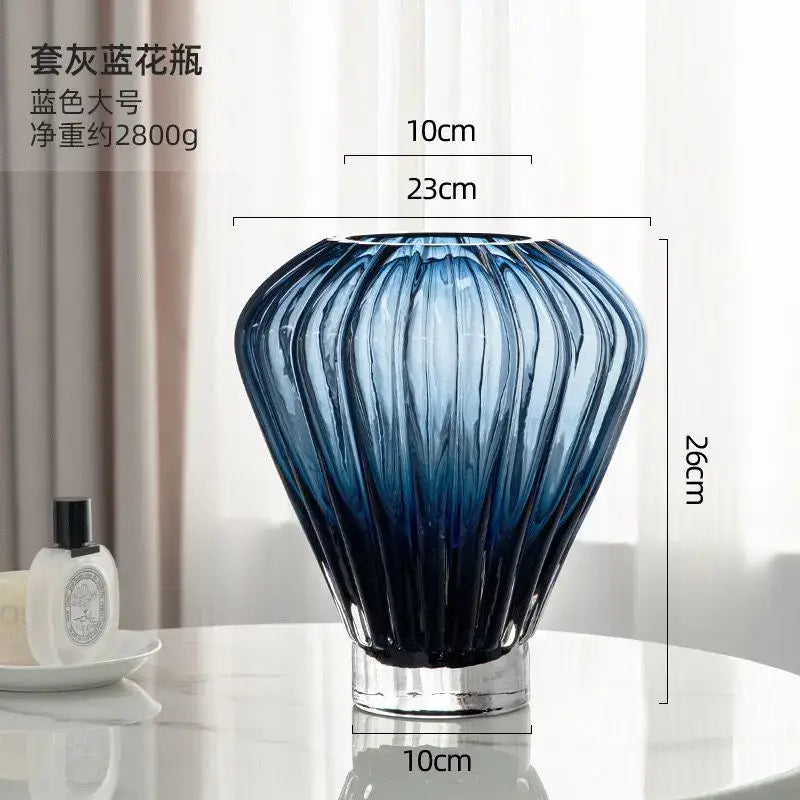 A sleek blue glass hot air balloon vase with vertical ribbed detailing and clear cylindrical base for living room decor
