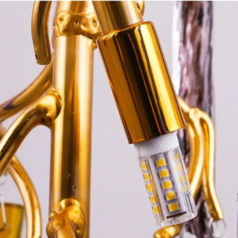Gold-finished led light bulb with cylindrical metallic housing and visible leds in decorbites crystal pendant chandelier
