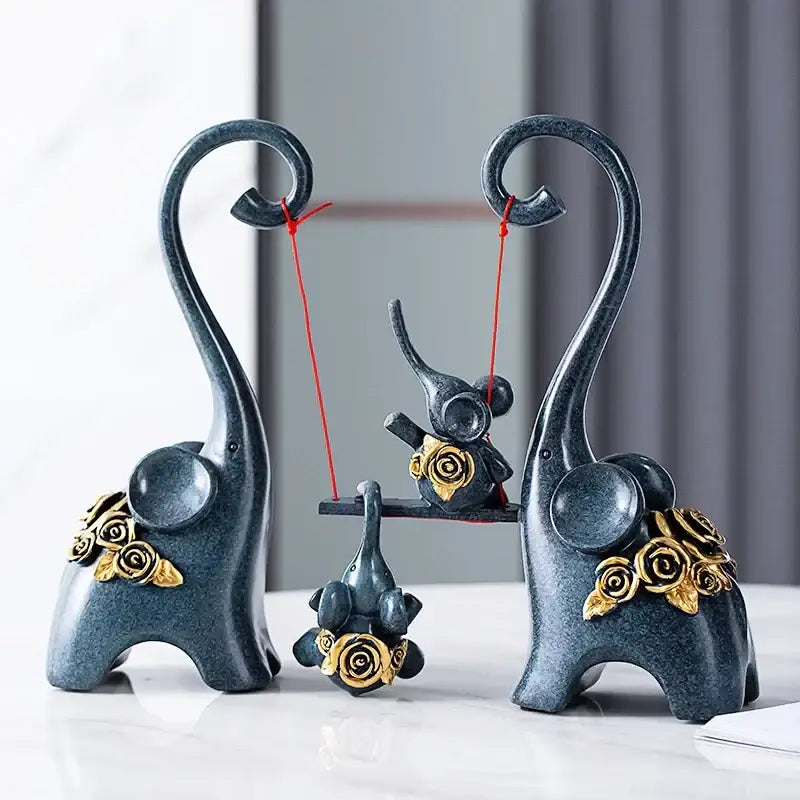 Dark blue ceramic elephant family swing sculpture with gold rose embellishments and curved trunks for living room decor