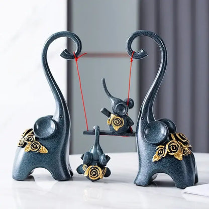 Dark blue ceramic elephant family swing sculpture with gold rose embellishments and curved trunks for living room decor