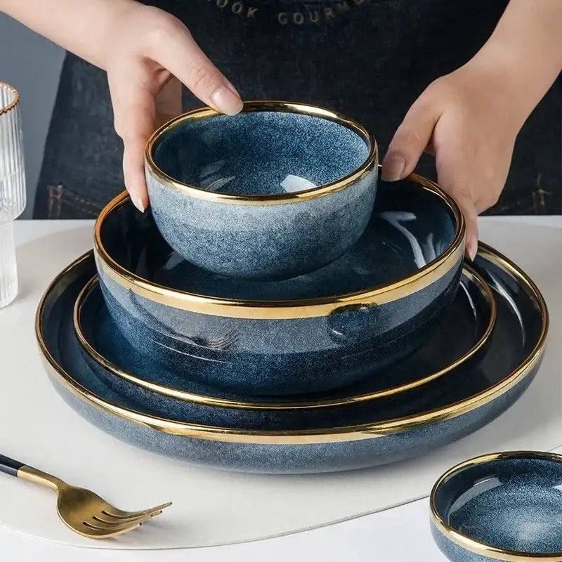 Deep blue ceramic plate set with gold rims featuring a blue gradient design for elegant dining room use