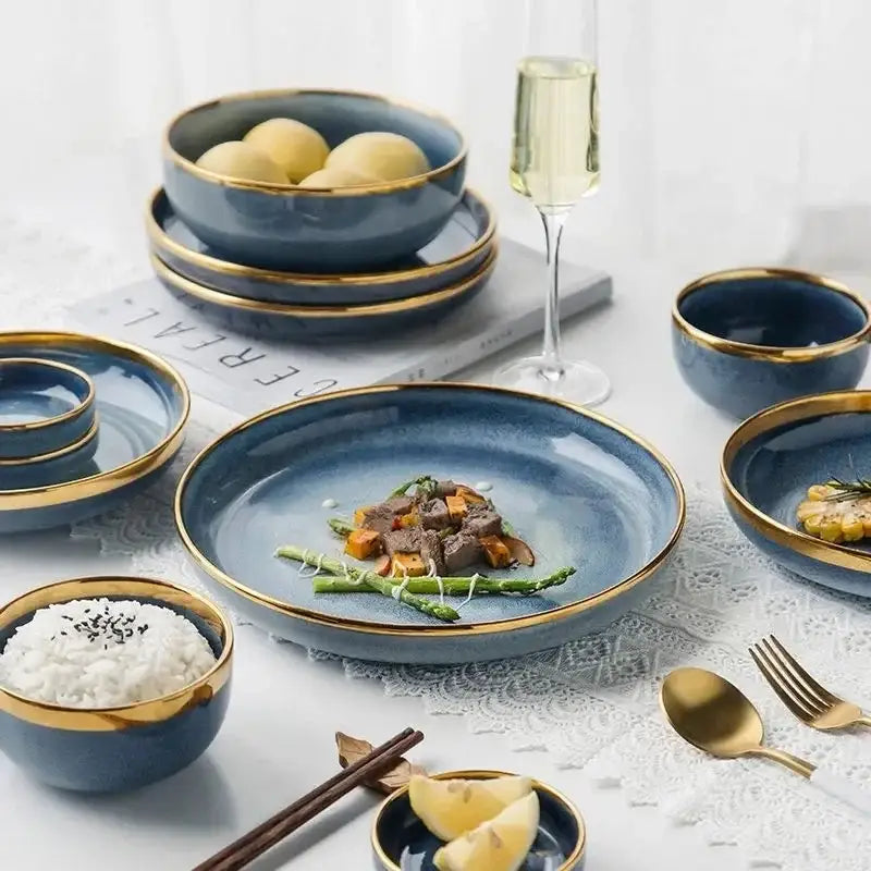 Deep blue ceramic plate set with elegant gold rims featuring a central plate holding a plated meal in blue gradient design