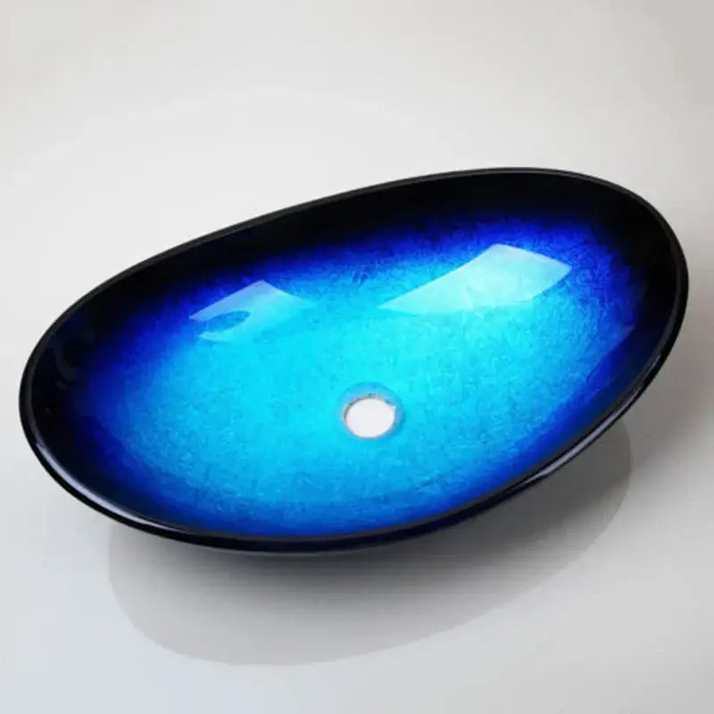 Vibrant blue gradient ceramic basin sink set with glossy black rim and tempered glass waterfall faucet for bathroom use