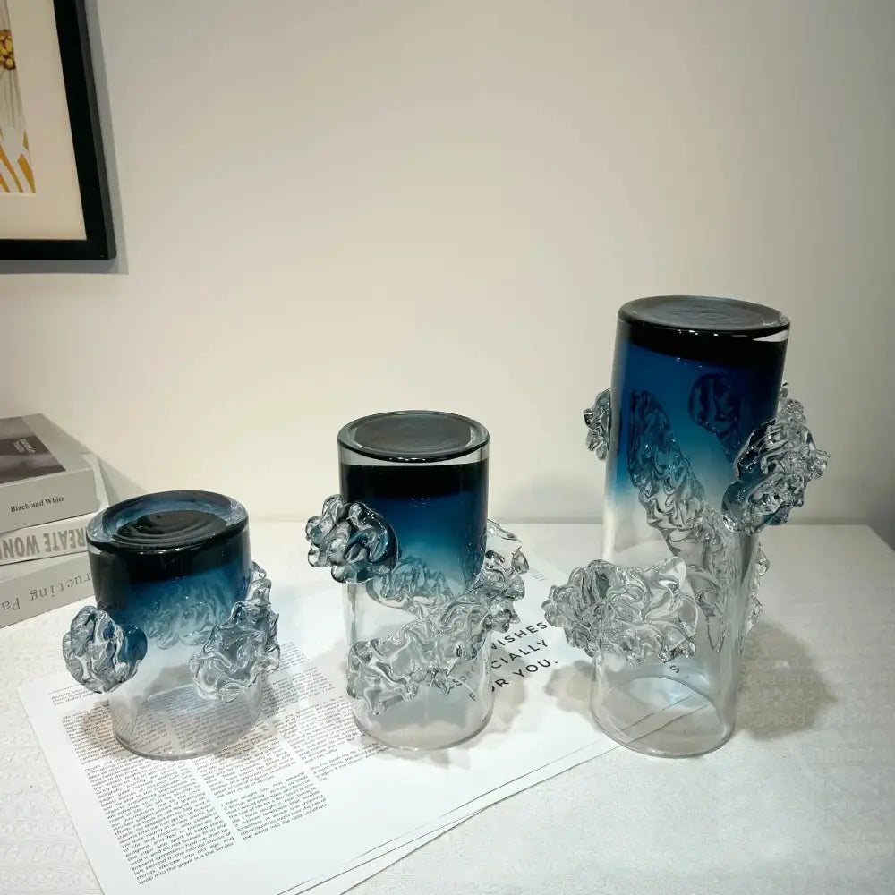 Three blue gradient wavy glass vases with clear sculpted wave-like embellishments for living room decor