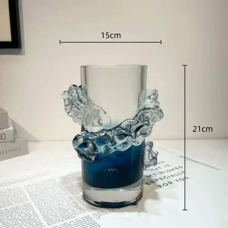 A translucent glass vase with a blue gradient wavy design and sculpted wave-like handles for living room decor