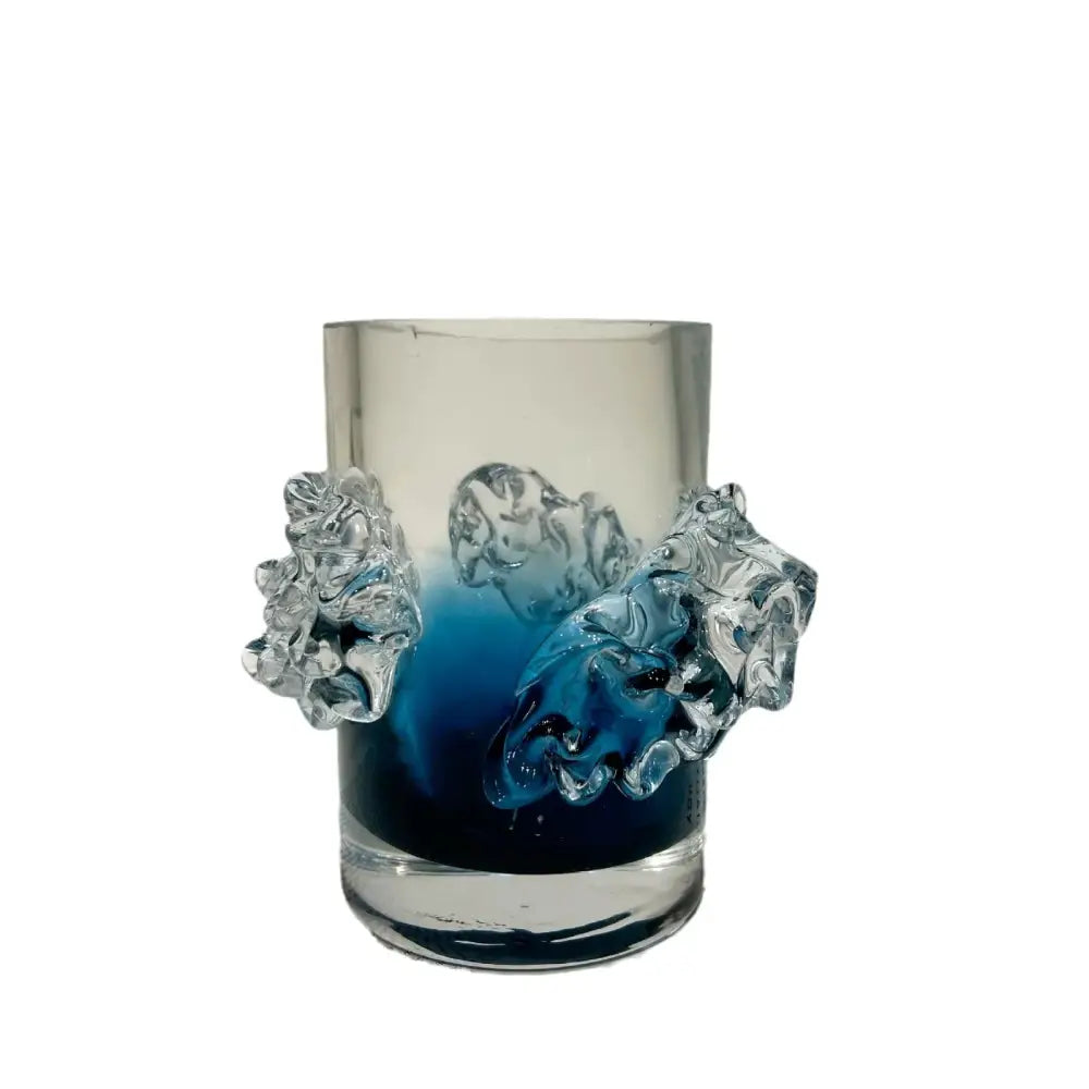 A translucent glass vase with blue gradient wavy interior and clear sculpted lion head handles for floral decor