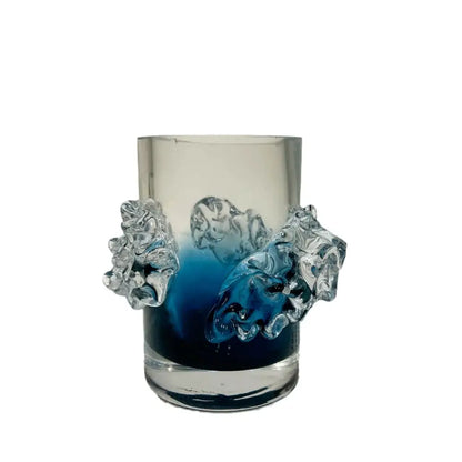 A translucent glass vase with blue gradient wavy interior and clear sculpted lion head handles for floral decor