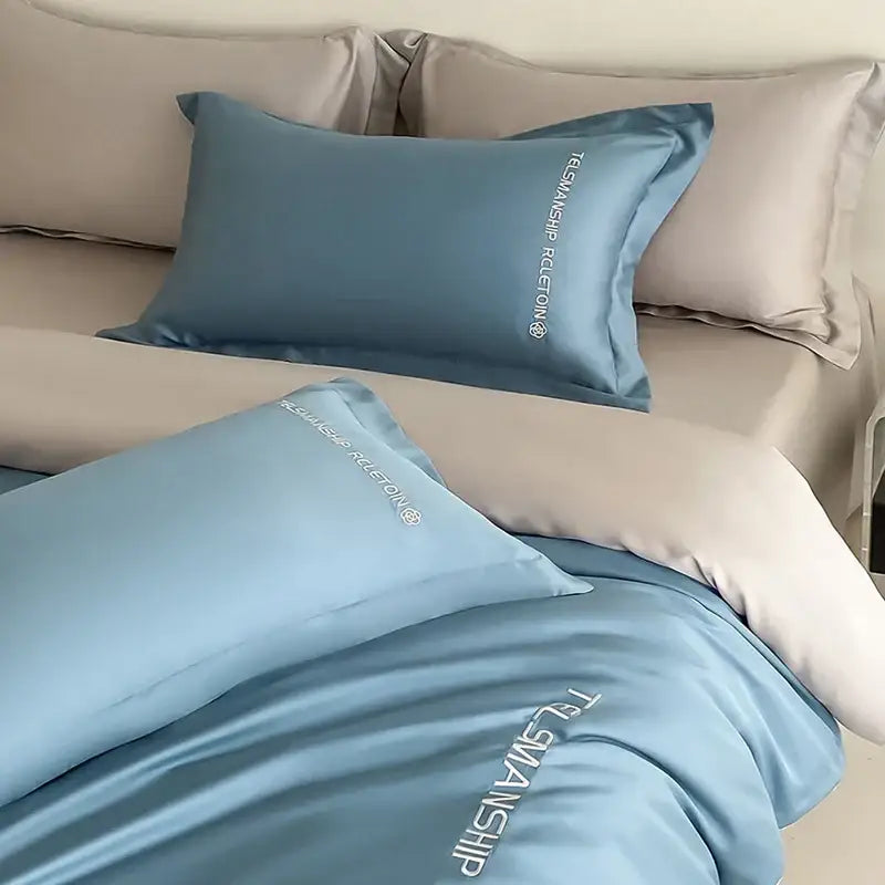 Light blue satin pillowcases with white embroidered text from decorbites cotton solid color bedding set