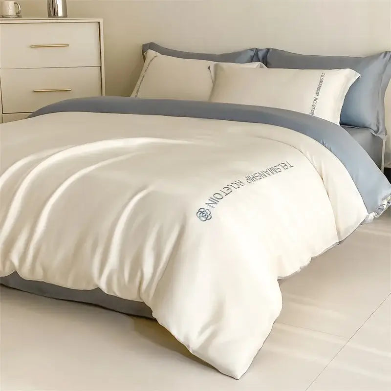 Cream-colored satin duvet cover with subtle gray border and embroidered brand logo from decorbites cotton solid bedding set