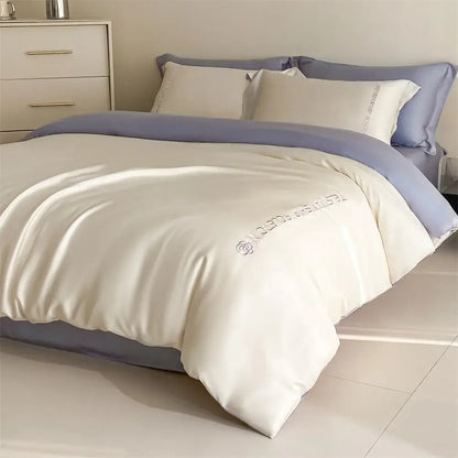 Cream-colored satin duvet cover with lavender trim and embroidered rose logo in decorbites cotton solid color bedding set