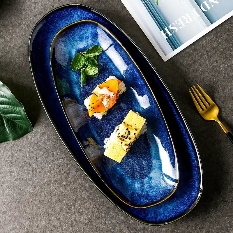 Deep blue ceramic oval sushi plate with glossy blue kiln glazed finish and gold-trimmed edges by decorbites blue kiln